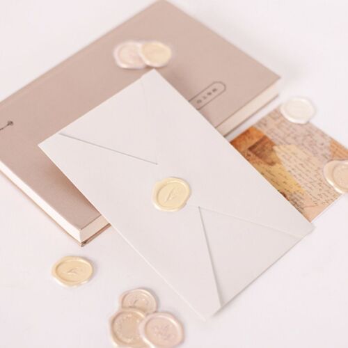 Elegant sealing wax stickers with embossed floral and word designs in soft pastel shades, arranged on a light background for display.