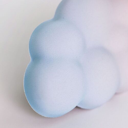 A close-up view showcasing the Sunset Cloud Wrist Cushion's soft pastel gradient and plush, cloud-like texture against a neutral background.