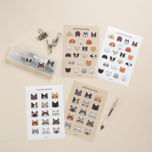 The image showcases various sheets of adorable cat and dog face stickers, with some transparent and removable options, alongside metal clips and a pen.