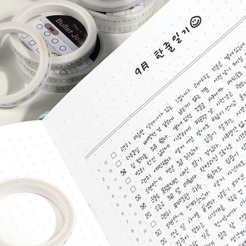 Loose tape strips cross a white background, highlighting the clean contrast of the printed black and gray markings.