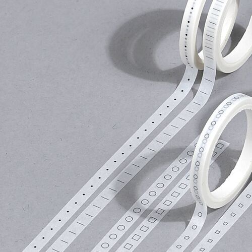 A close-up emphasizes repeating dots, ticks, circles, and square checkboxes printed along the narrow tape.