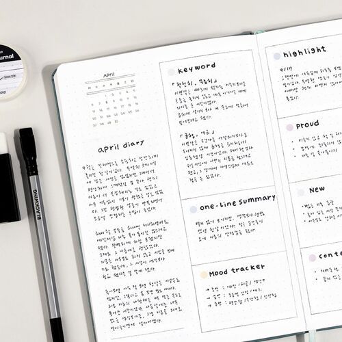 An open journal shows gray tape accents used with a pen for practical headings and page organization.