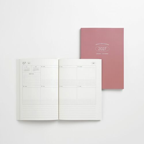 Open planner reveals minimalist weekly layout with clean lines, soft white pages, and subtle gray accents, complemented by a muted pink cover.