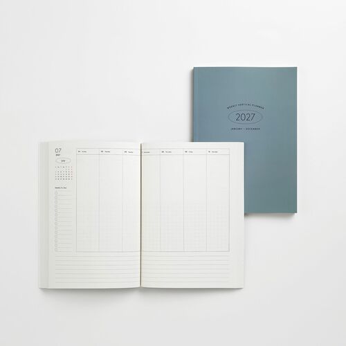 Open planner revealing clean, minimalistic weekly layout with subtle grid lines, set against a sleek blue cover for a modern aesthetic.