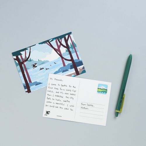 The lakeside orca design is paired with its writable reverse, demonstrating the divided layout, message lines, and stamp placement.