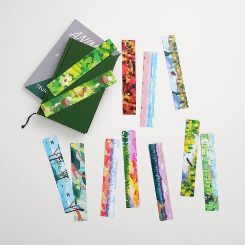 Several bookmarks lie beside decorative tape and an open book, emphasizing their use for reading and journaling.