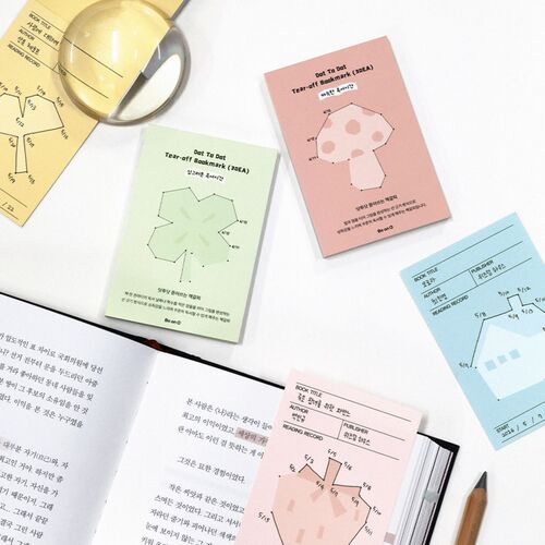 Pastel bookmark sheets are arranged around a magnifying glass, highlighting the five-design reading record collection.