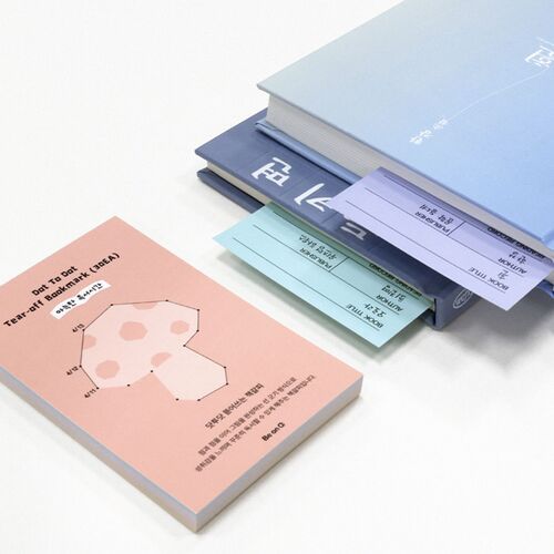 The stacked tear-off set shows layered paper edges, with a pink cover sheet and loose bookmarks ready to use.