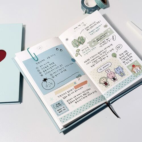A pale Mint journal sits beside an open decorated spread, emphasizing the cover-to-page transition.