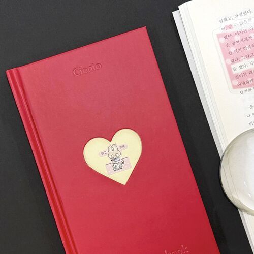 An Apple journal is shown against a dark background with its smooth cover and personalized heart detail.
