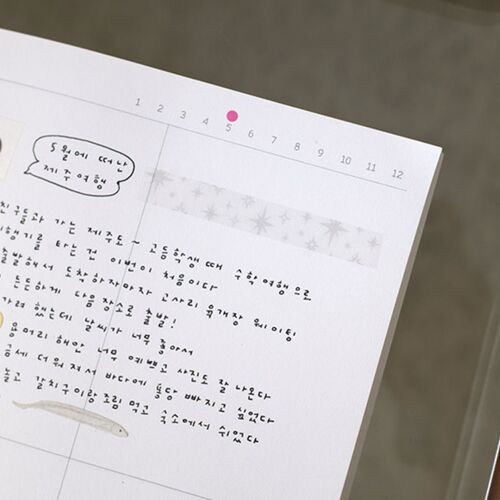 On a journal page, a small cat sticker and a pale accent strip appear alongside handwritten notes.