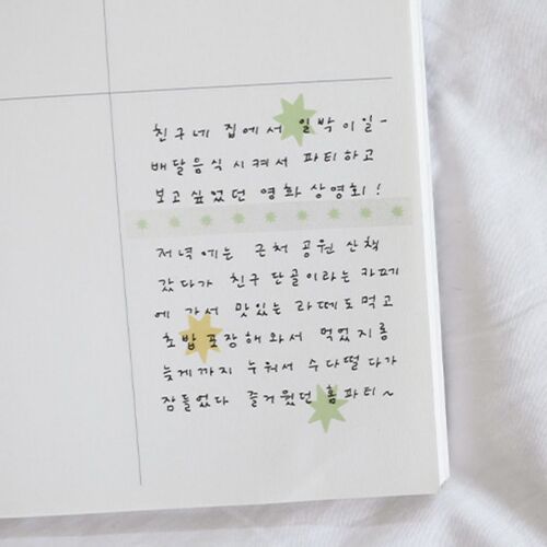The close-up highlights a Pale Green starburst and a Yellow starburst placed between handwritten journal lines.