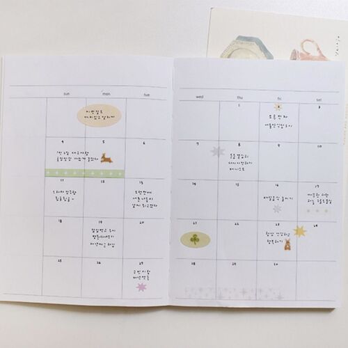 A monthly calendar spread shows the stickers marking dates with small stars, colored strips, and larger decorative shapes.
