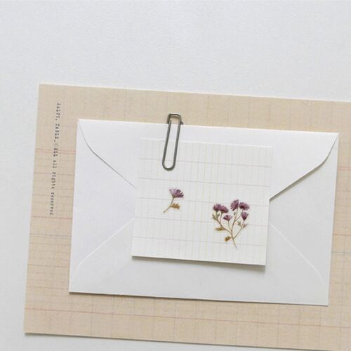 A blue hydrangea sticker sits on a translucent envelope, adding a quiet botanical detail to the front panel.