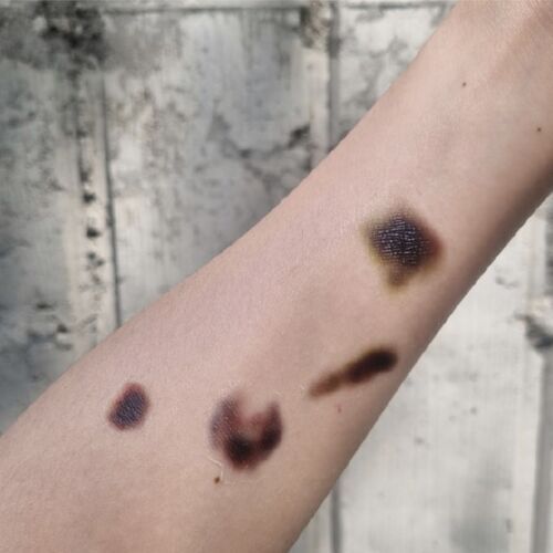 Bruise Effect tattoos are shown settled on an arm, with dark centers and softly blended edges across separate placements.