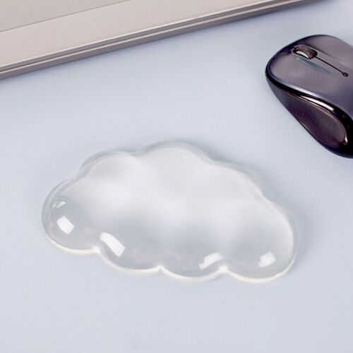 Placed beside a wireless mouse, the cushion shows how its low cloud shape fits naturally into a computer desk setup.