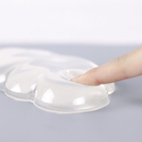 A finger presses into the cushion’s raised surface, showing the soft silicone material and gently cushioned response.