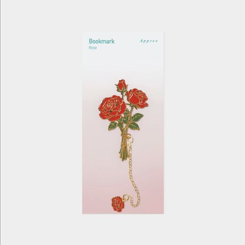 A hand places the Rose bookmark into an open book, showing how the floral piece marks a page.
