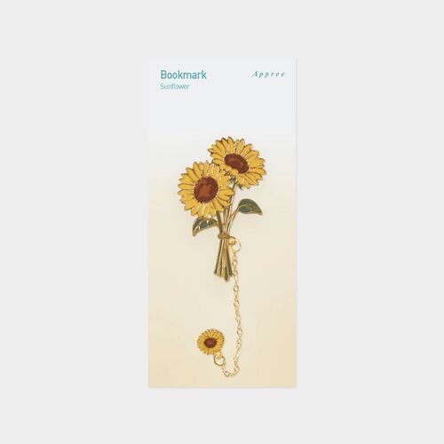 Sunflower rests across an open book with its chain extending toward the bottom corner.