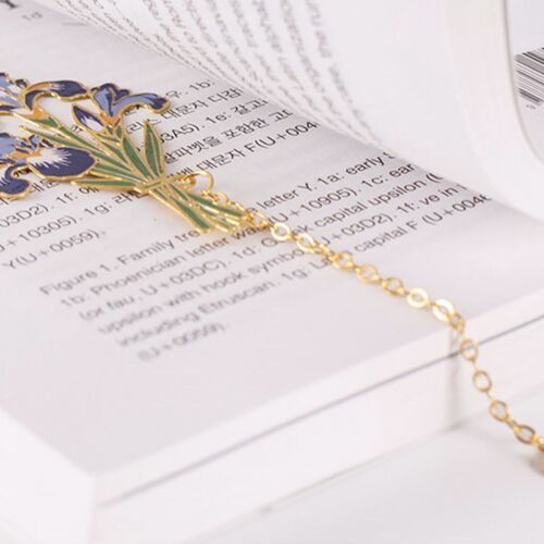 Iris rests diagonally across printed pages while its gold chain extends toward the lower edge.