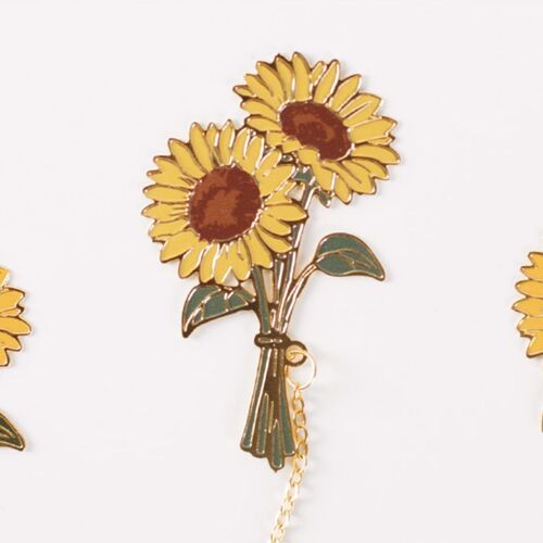 The matching sunflower charm hangs from the book’s edge, echoing the larger floral design.