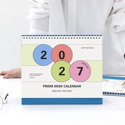 The calendar is displayed in an office setting with writing space visible across the monthly layout.