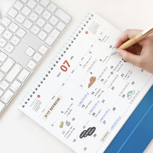 A July page is being written on, demonstrating the calendar’s roomy date boxes for planning.
