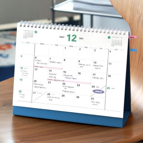 The December 2027 page displays broad writing areas and colored date accents in the standing frame.