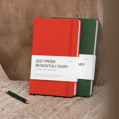 Tomato Red and Forest planners are displayed upright with their contrasting colors and white labels.