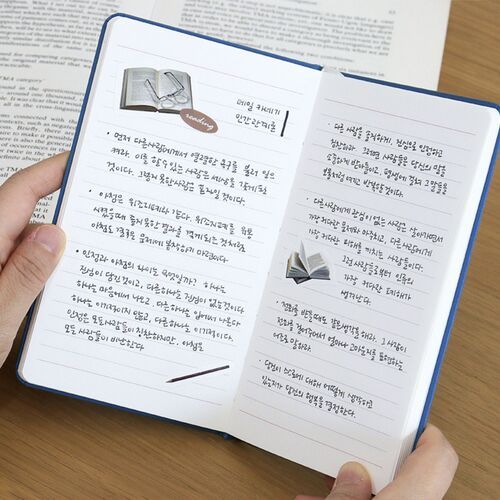 Several planners are stacked to show the slim book block, rounded edges, elastic bands, and varied cover colors.