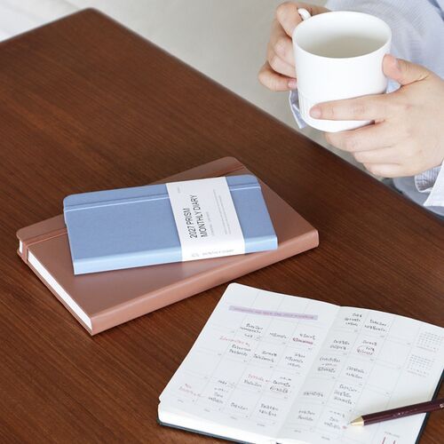 Multiple color options are arranged on a white surface beside an open planner, highlighting the collection’s coordinated design.