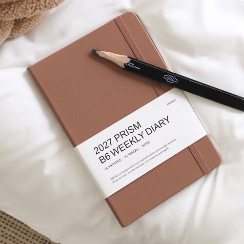 A stack of planners in varied colors shows the consistent B6 proportions and labeled spines.