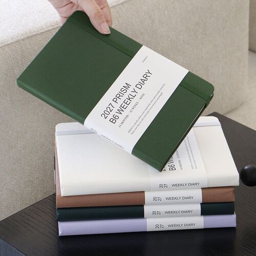 The Cloud planner stands on a wooden shelf, showing its minimal white cover and softly rounded corners.