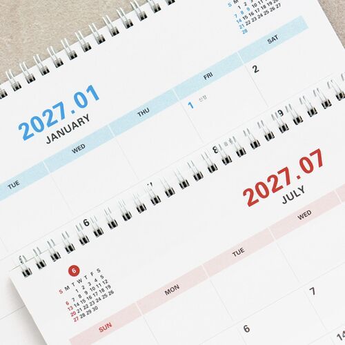 The calendar is angled on a desk beside a keyboard and sketches, highlighting its use for project planning.