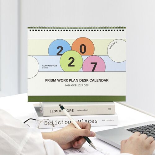 The calendar appears on a bright shelf beside another open month, showing how it can remain visible in a shared workspace.