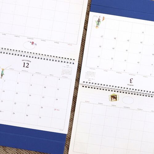 Open calendar pages show the blue folded base and wide monthly grids from different points in the schedule.