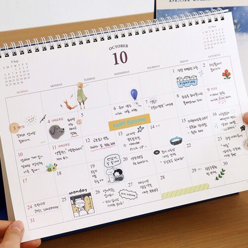 A close view of the October page shows the white wire binding and detailed writing space across the full grid.