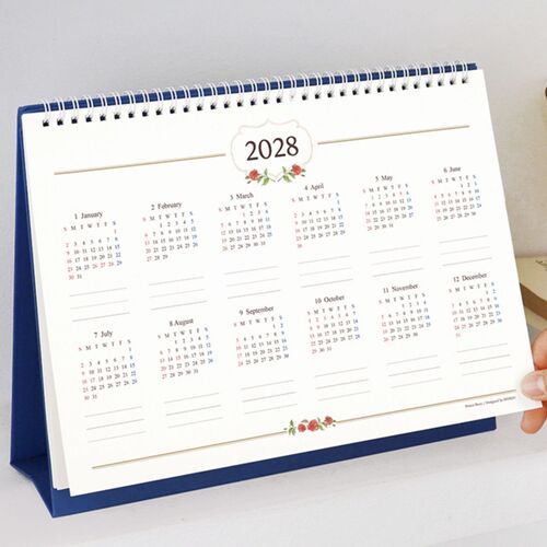 A close view highlights the spiral binding, month heading, and neat grid structure on a filled calendar page.