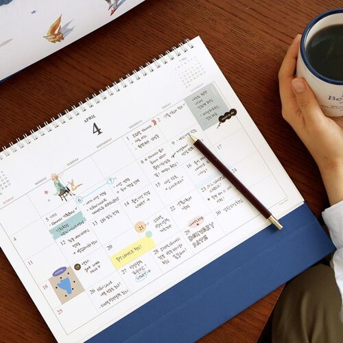 A wider desk scene pairs the upright calendar with a writing surface and supplies for everyday planning.