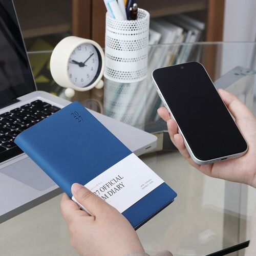 A Blossom scheduler is lifted above stacked volumes, showing the flexible cover and compact rectangular shape.