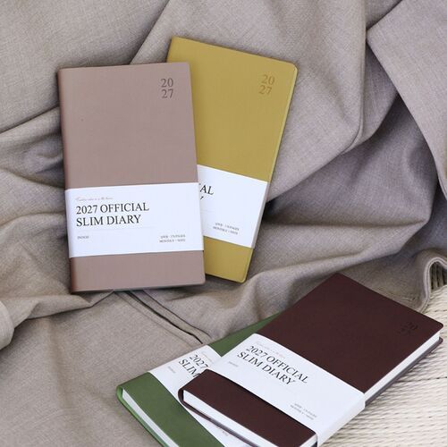 A color stack displays multiple schedulers horizontally, making the slim binding and varied cover palette easy to compare.