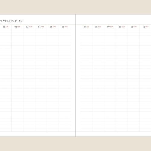 An open monthly scheduler sits on a desk beside a laptop and writing tools for work planning.