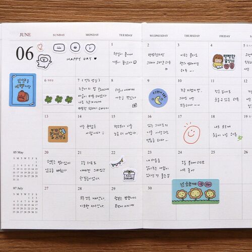 A Red Bean scheduler rests near a pen and books, ready for notes or monthly planning.