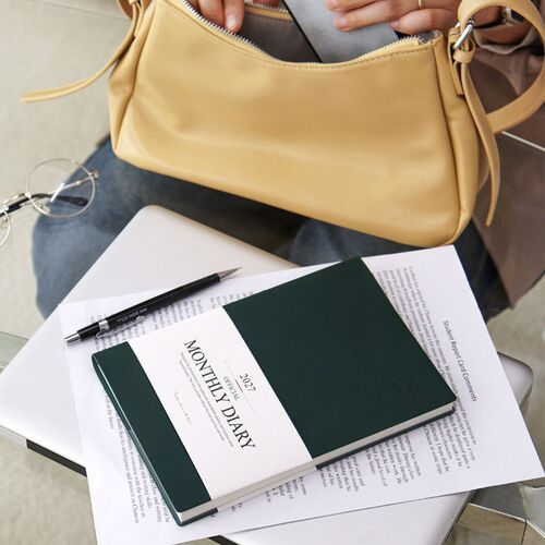The scheduler is shown beside a shoulder bag, illustrating its convenient use during everyday travel.