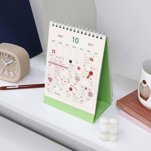 Photo 14: The Pop Orange cover lies on a desk with a pink heart-and-circle sticker sheet and a blue pencil nearby.