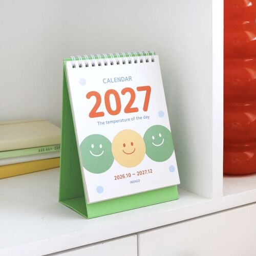 Photo 18: The calendar is styled with books and a clock, showing how its compact standing format fits neatly into a workspace.