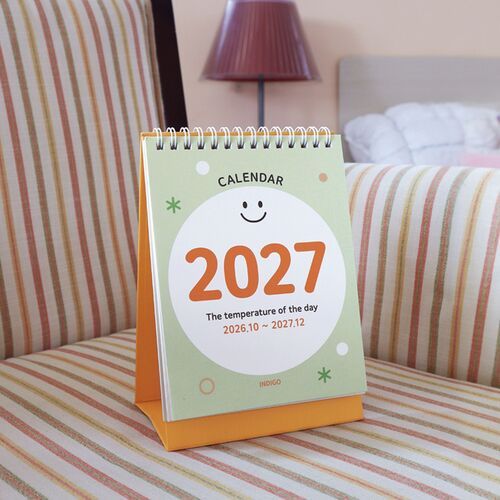 Photo 3: Smile Green and Pop Orange calendars appear on a tabletop, with one showing the monthly grid and the other its illustrated cover.