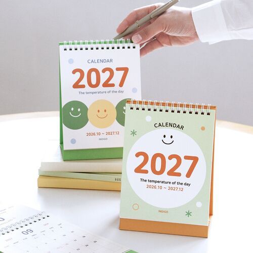 Photo 22: The Pop Orange calendar stands on a round table with its sticker sheet and pencil placed in front.