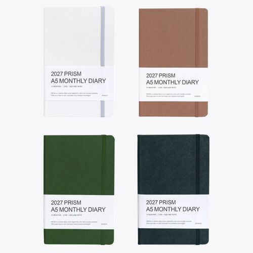 A close view shows the planner’s white paper block, rounded hardcover edges, and elastic closure wrapped around the cover.