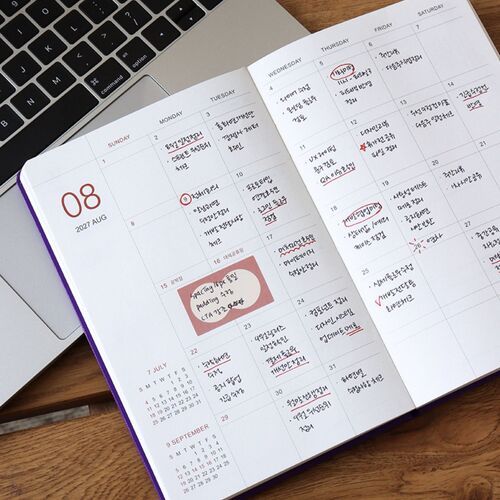 A monthly spread is shown close-up with weekday columns, date boxes, and handwritten notes filling the available space.